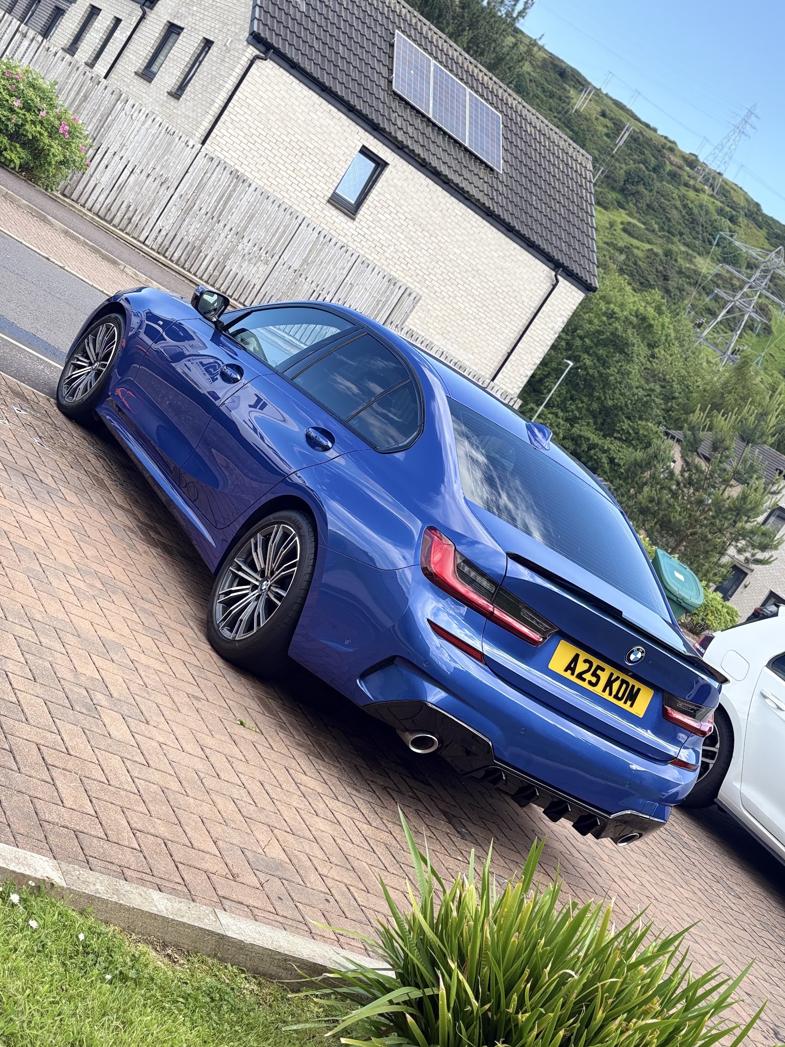 The rear of a blue BMW 3 Series showing a deep gloss after detailing