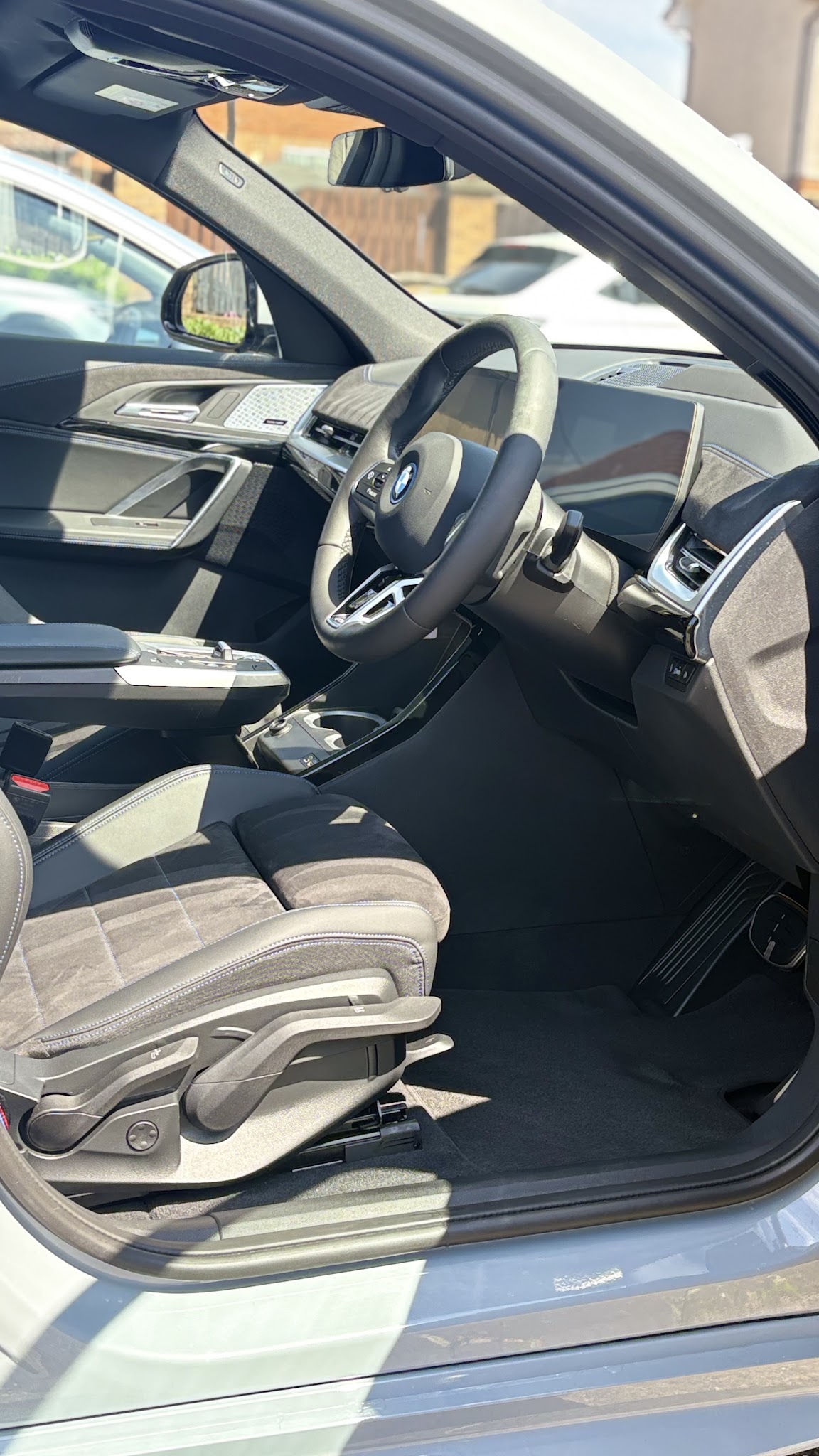 A vacuumed and wiped-down BMW interior seen through the open driver’s door